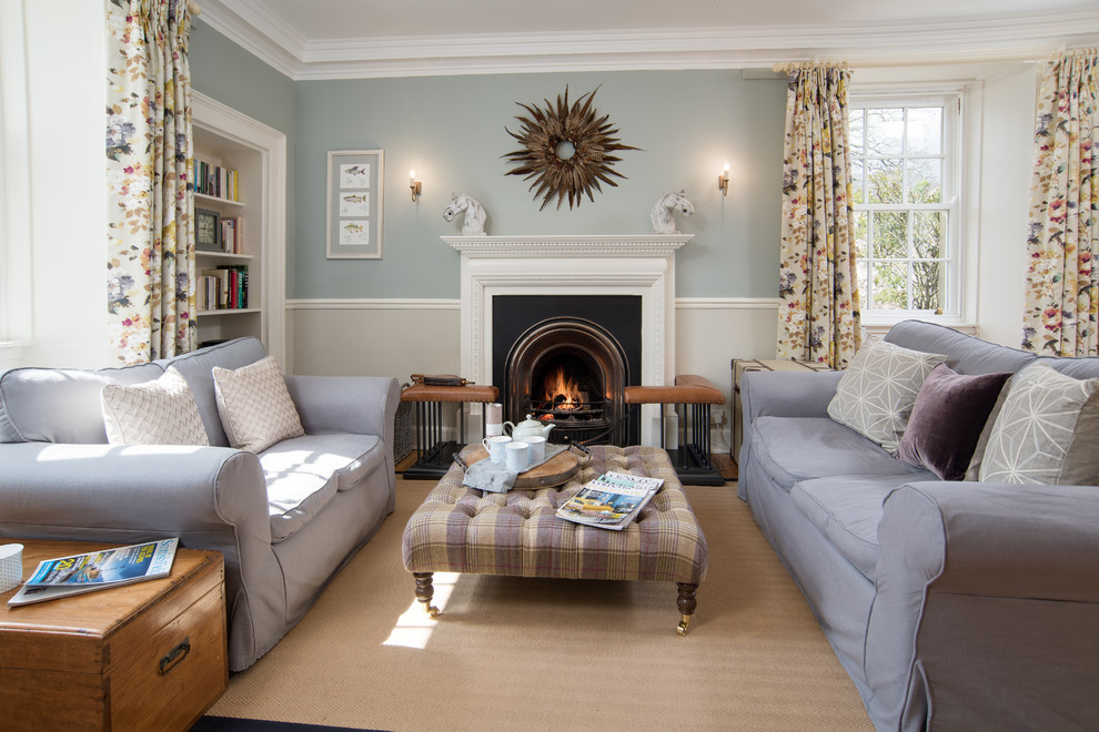 Réalisation d'un grand salon champêtre fermé avec un mur bleu, moquette, une cheminée standard, un manteau de cheminée en plâtre et un sol beige.
