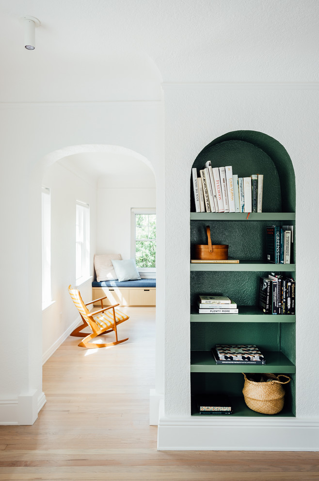 Esempio di un soggiorno nordico di medie dimensioni e aperto con libreria, pareti bianche e parquet chiaro