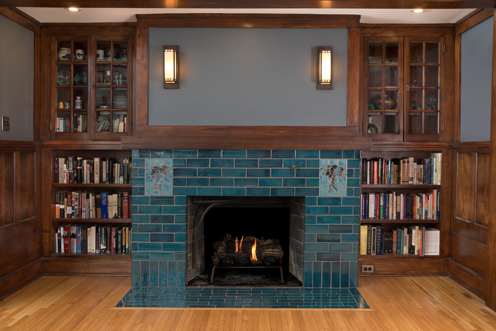 Bild på ett mellanstort amerikanskt allrum med öppen planlösning, med ett bibliotek, grå väggar, klinkergolv i keramik, en standard öppen spis, en spiselkrans i trä och blått golv