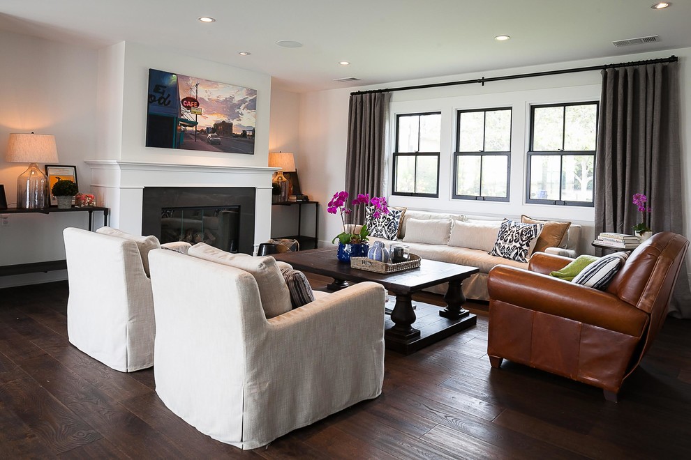 Inspiration for a mid-sized country open concept dark wood floor and brown floor living room remodel in San Diego with white walls, a standard fireplace and a wood fireplace surround
