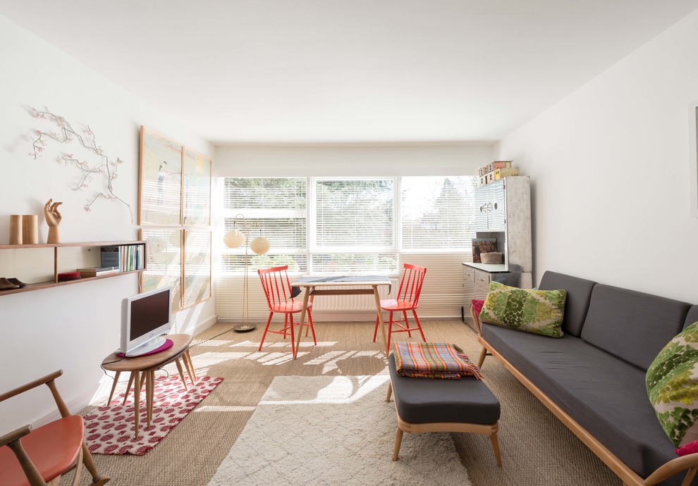 На фото: гостиная комната в современном стиле с белыми стенами, ковровым покрытием и отдельно стоящим телевизором