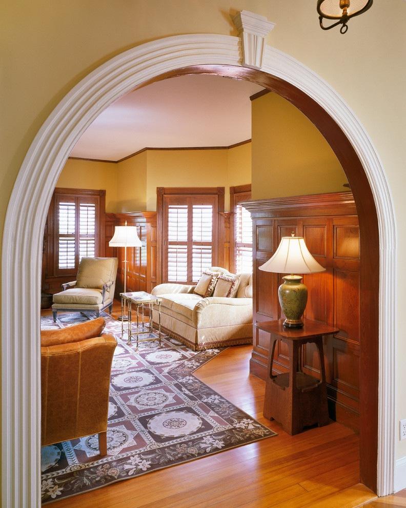 Esempio di un soggiorno classico chiuso con pareti gialle e pavimento in legno massello medio