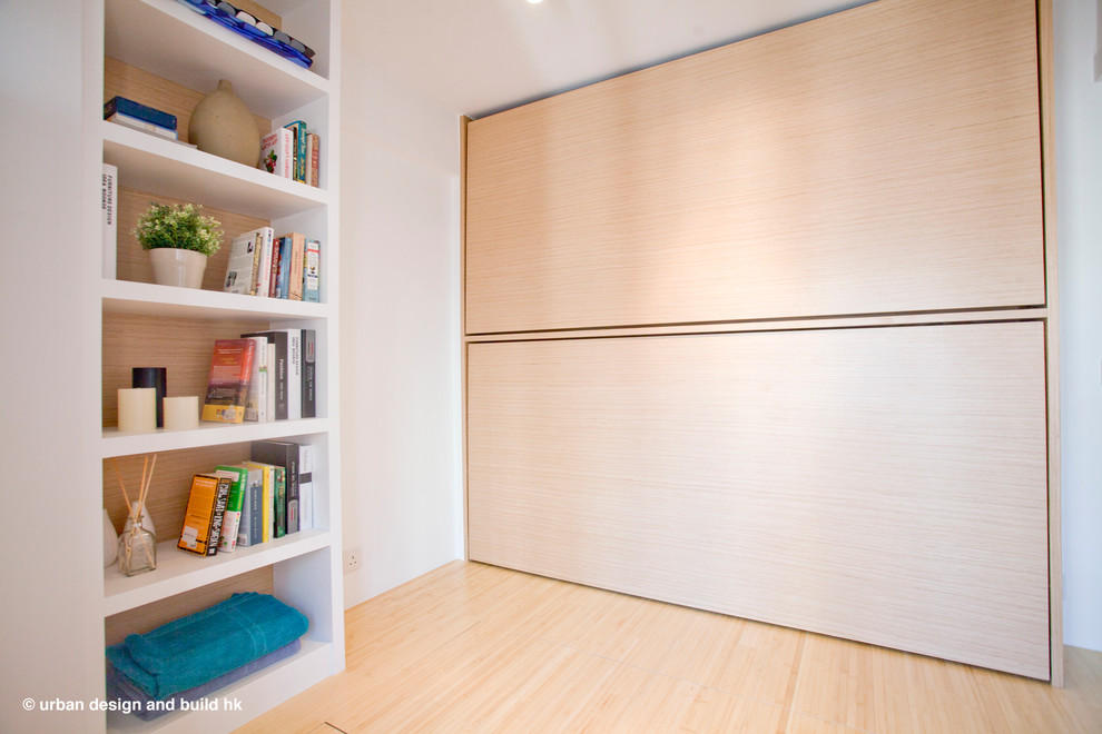 Esempio di un soggiorno minimalista di medie dimensioni e aperto con pavimento in bambù e parete attrezzata