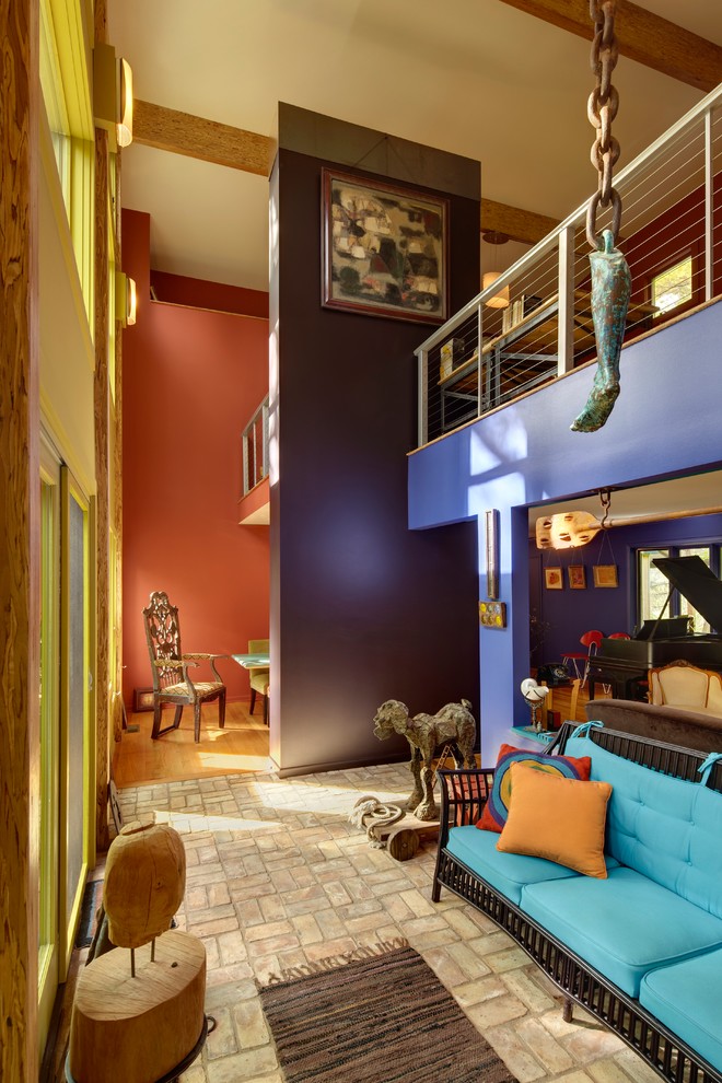На фото: двухуровневая гостиная комната среднего размера в современном стиле с разноцветными стенами, кирпичным полом и бежевым полом без камина, телевизора с