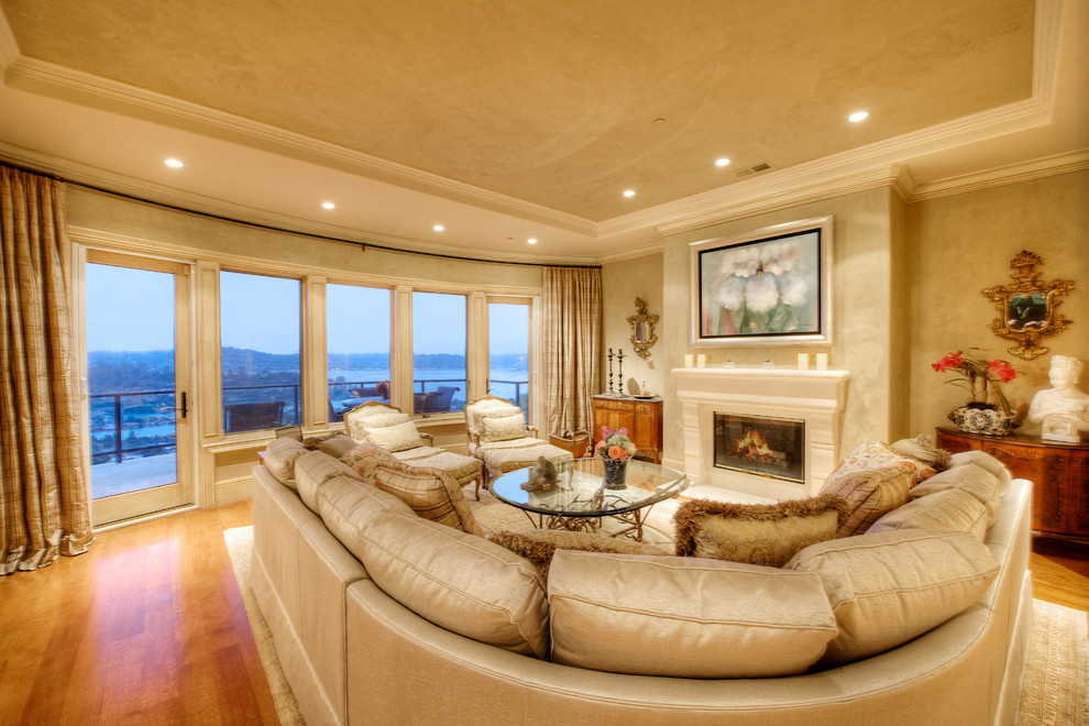 Example of a large tuscan formal and enclosed medium tone wood floor living room design in San Francisco with beige walls, a standard fireplace and a plaster fireplace