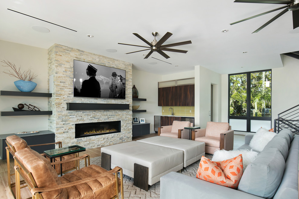 Photo of a medium sized modern open plan living room in Tampa with a home bar, white walls, porcelain flooring, a ribbon fireplace, a stone fireplace surround, a wall mounted tv and brown floors.