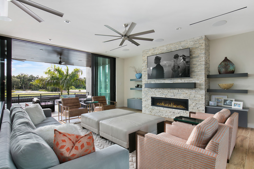 Mittelgroßes, Offenes Modernes Wohnzimmer mit Porzellan-Bodenfliesen, Gaskamin, Kaminumrandung aus Stein, TV-Wand, braunem Boden und grauer Wandfarbe in Tampa