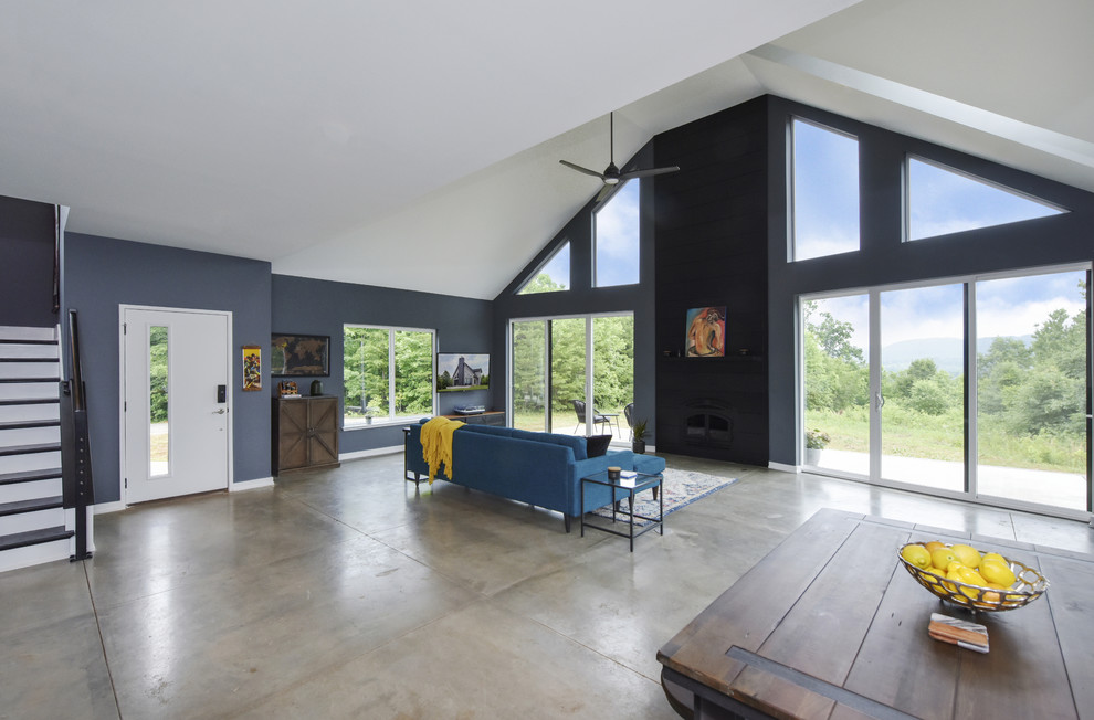 Offenes Klassisches Wohnzimmer mit grauer Wandfarbe, Betonboden, Kamin, TV-Wand und grauem Boden in Sonstige
