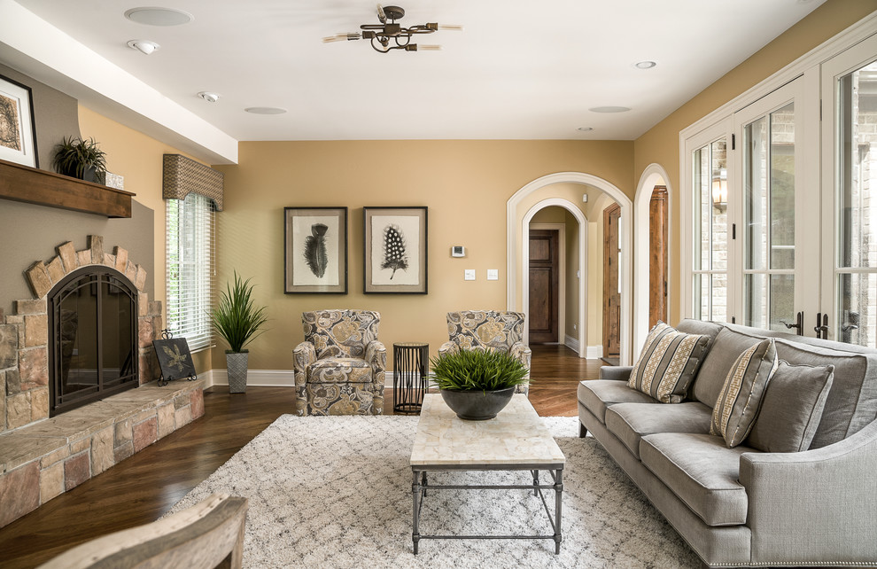 Klassisches Wohnzimmer mit brauner Wandfarbe, dunklem Holzboden, Kamin, Kaminumrandung aus Stein und braunem Boden in Chicago