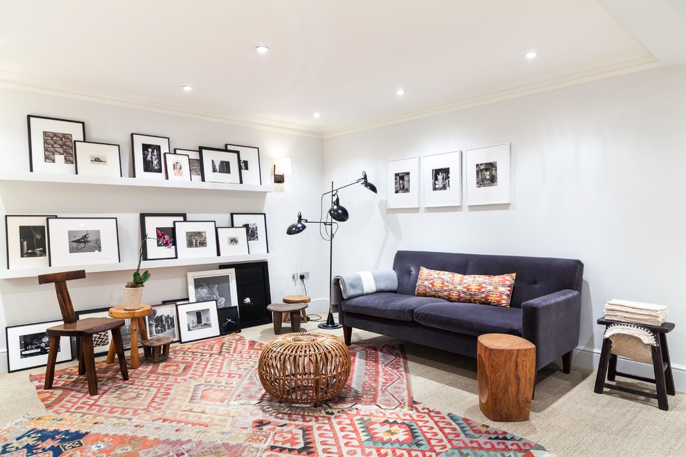 This is an example of an eclectic living room in London with white walls and carpet.
