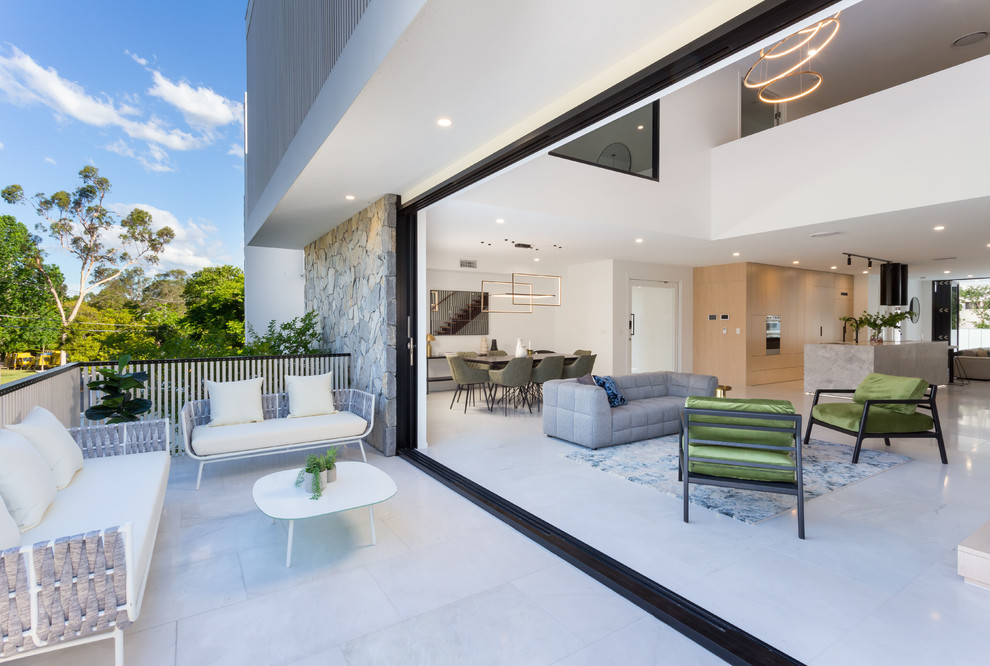Großes, Repräsentatives, Fernseherloses, Offenes Modernes Wohnzimmer mit weißer Wandfarbe, Marmorboden, Kamin, Kaminumrandung aus Stein und weißem Boden in Brisbane