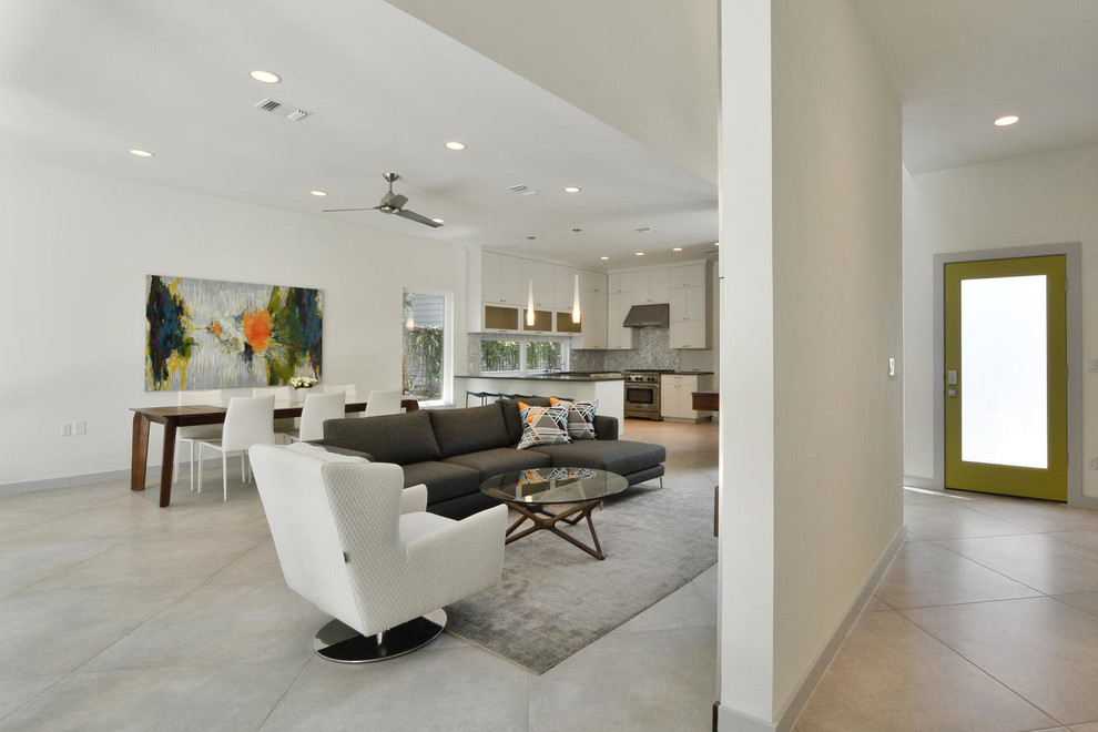 Cette image montre un salon minimaliste de taille moyenne et ouvert avec une salle de réception, un mur blanc, un sol en carrelage de porcelaine et un téléviseur dissimulé.