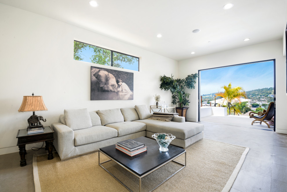 Photo of a large contemporary open plan living room in Los Angeles with white walls, concrete flooring, no fireplace, no tv and grey floors.
