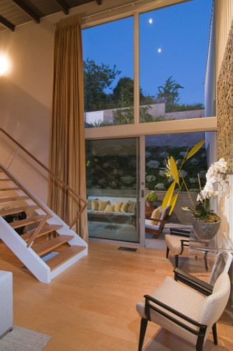 Esempio di un soggiorno minimalista di medie dimensioni e stile loft con libreria, pareti bianche, parquet chiaro, camino bifacciale e cornice del camino in mattoni