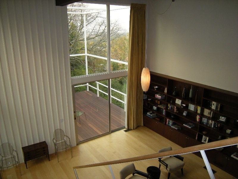 Foto di un soggiorno minimalista di medie dimensioni e stile loft con libreria, pareti bianche, parquet chiaro, camino bifacciale e cornice del camino in mattoni