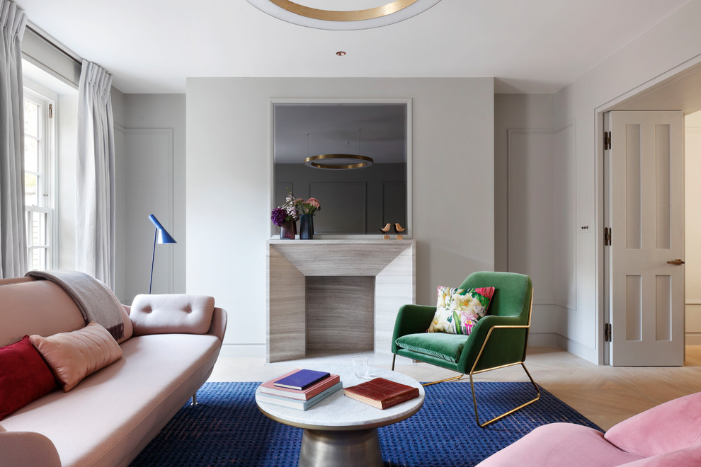 Immagine di un soggiorno di medie dimensioni con pareti grigie, parquet chiaro, camino classico e pavimento beige