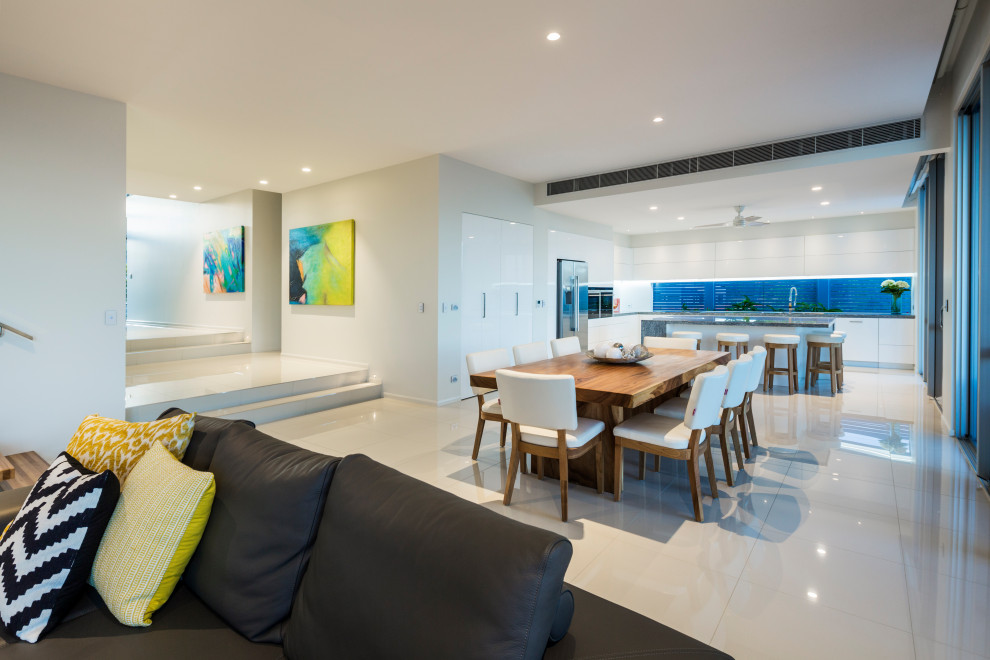 Repräsentatives, Offenes Modernes Wohnzimmer mit Porzellan-Bodenfliesen, TV-Wand und weißem Boden in Cairns