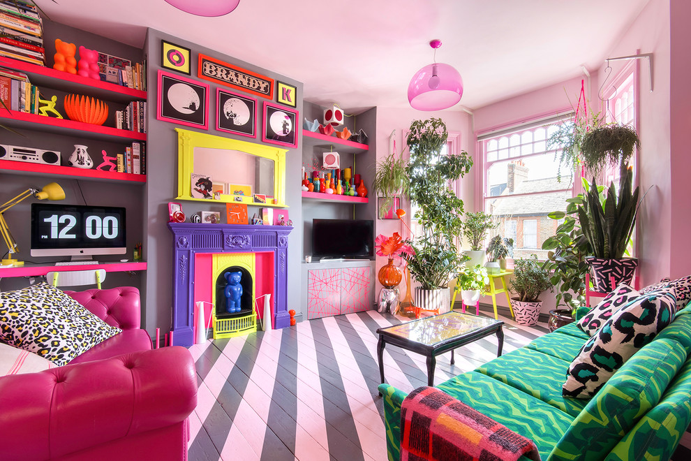 Ejemplo de salón bohemio de tamaño medio con paredes rosas, suelo de madera pintada, todas las chimeneas, televisor independiente y suelo multicolor