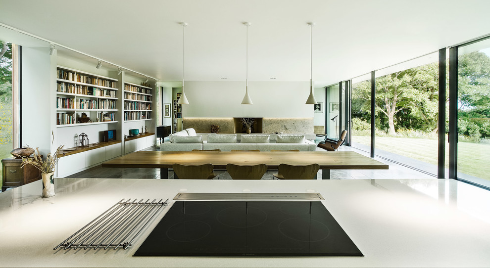 Trendy open concept living room photo in Hampshire with white walls, a standard fireplace and a concrete fireplace