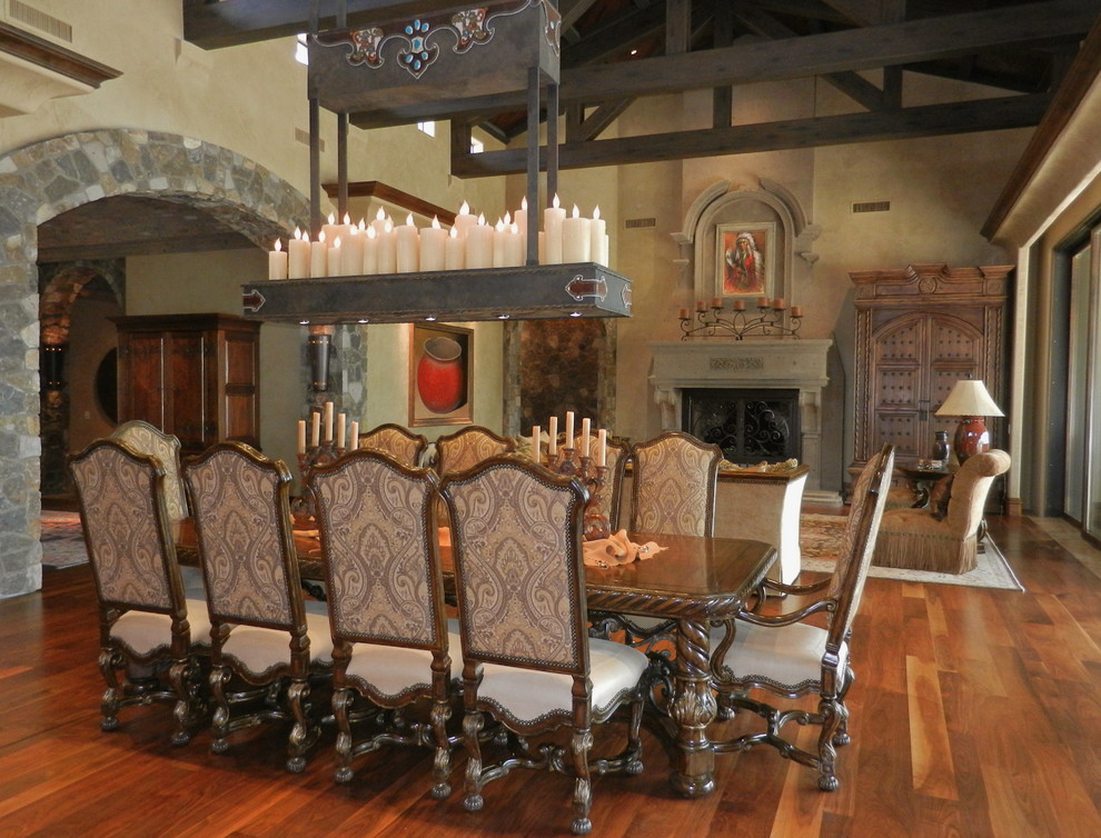 Idée de décoration pour une très grande salle à manger chalet avec un mur beige, un sol en bois brun, une cheminée standard et un manteau de cheminée en pierre.