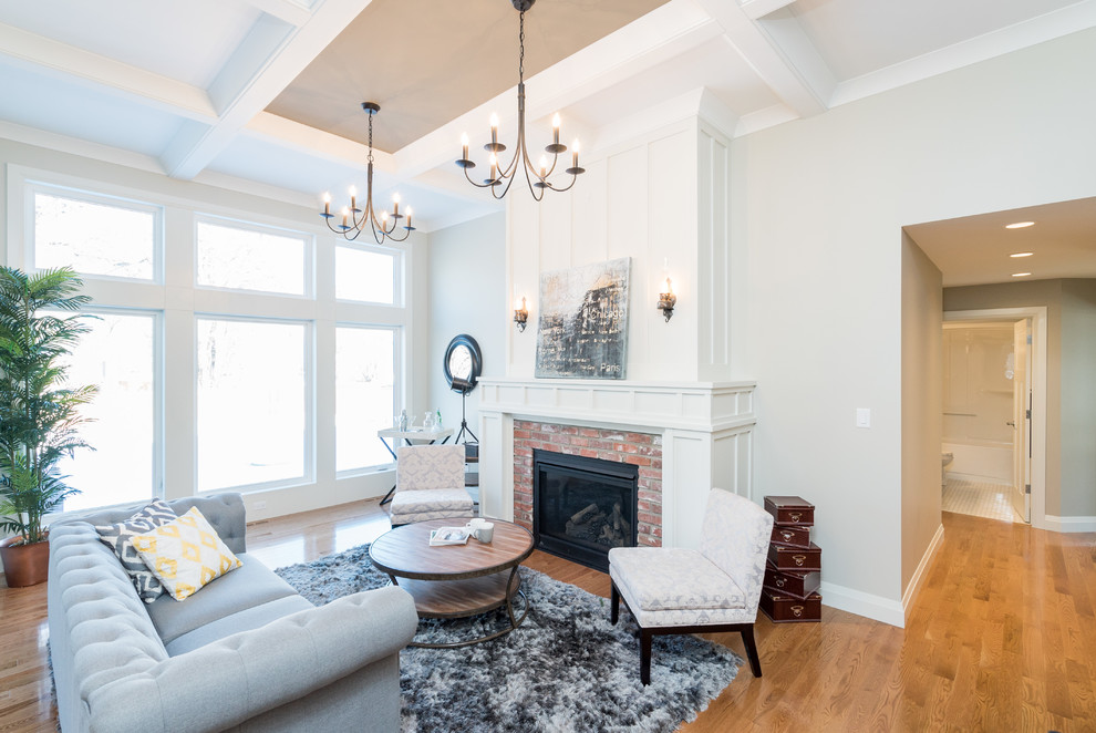 This is an example of a medium sized classic enclosed living room in Other with grey walls, light hardwood flooring, a standard fireplace and a brick fireplace surround.