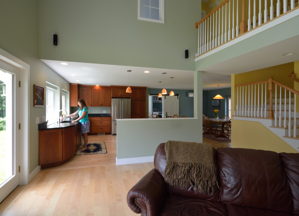 Стильный дизайн: двухуровневая гостиная комната в стиле кантри с зелеными стенами, светлым паркетным полом, двусторонним камином, фасадом камина из плитки и телевизором в углу - последний тренд