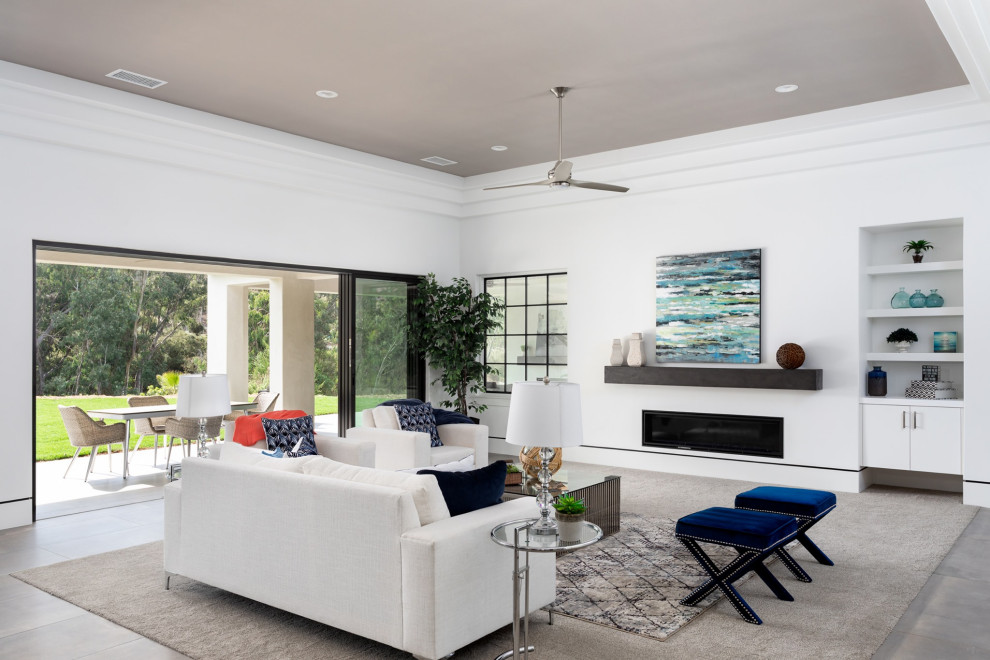 Offenes Modernes Wohnzimmer mit weißer Wandfarbe, Gaskamin und grauem Boden in San Diego
