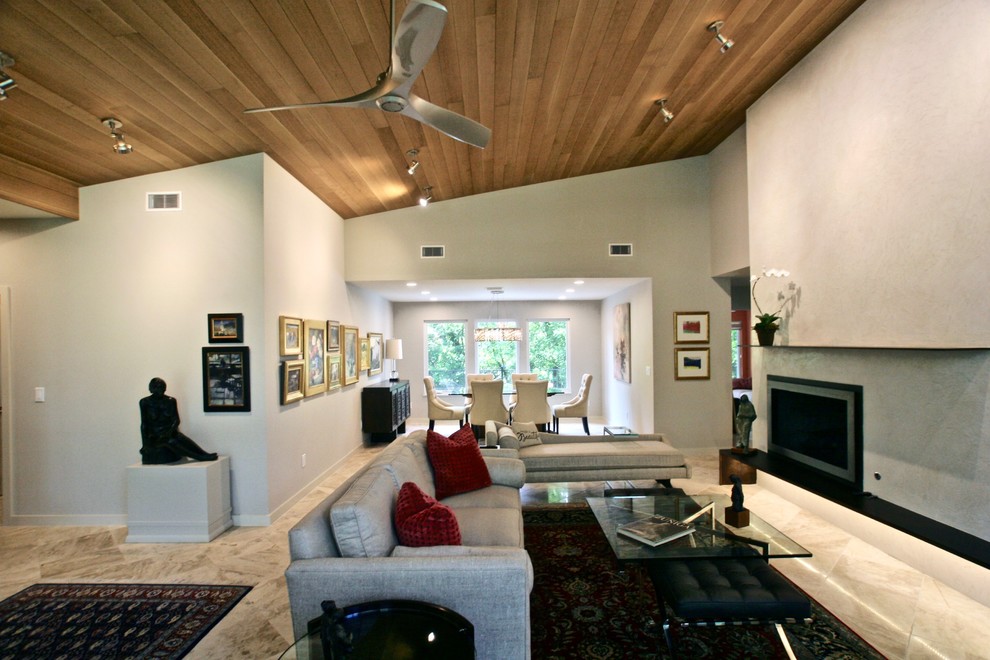 This is an example of a large traditional open plan living room in Austin with white walls, a plastered fireplace surround and multi-coloured floors.