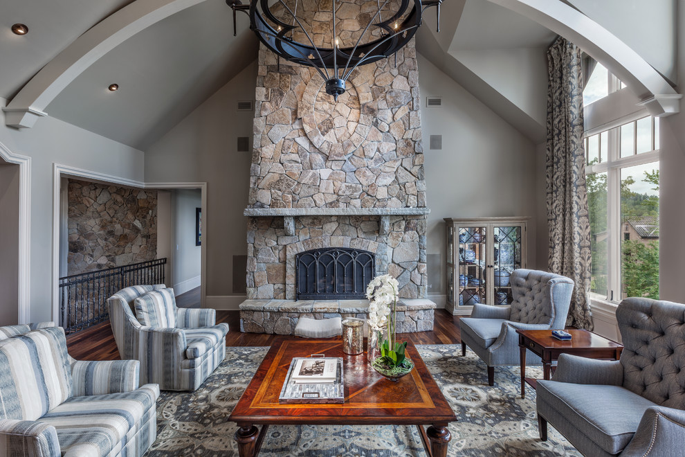 This is an example of a classic formal open plan living room in Other with grey walls, dark hardwood flooring, a standard fireplace and a stone fireplace surround.