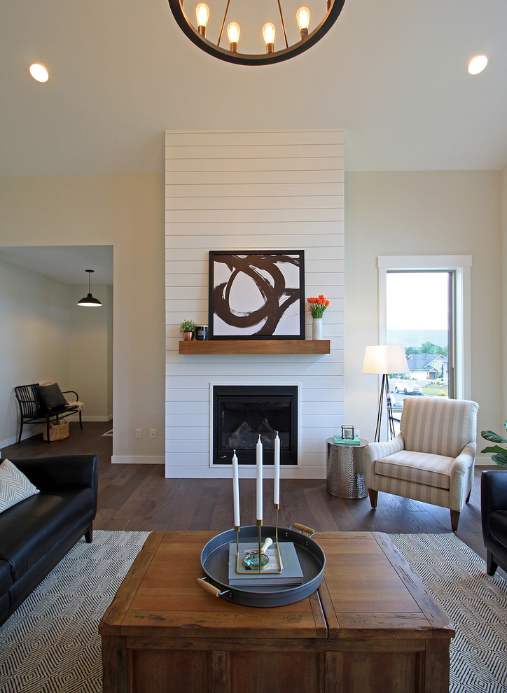 Example of a large country open concept dark wood floor living room design in Seattle with gray walls, a standard fireplace and a wood fireplace surround