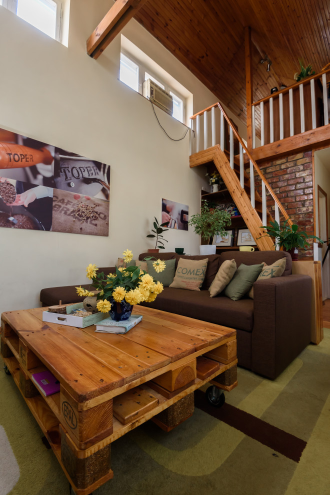Kleines Industrial Wohnzimmer ohne Kamin, im Loft-Stil mit gelber Wandfarbe, hellem Holzboden, freistehendem TV, Holzdecke und Ziegelwänden in Sonstige