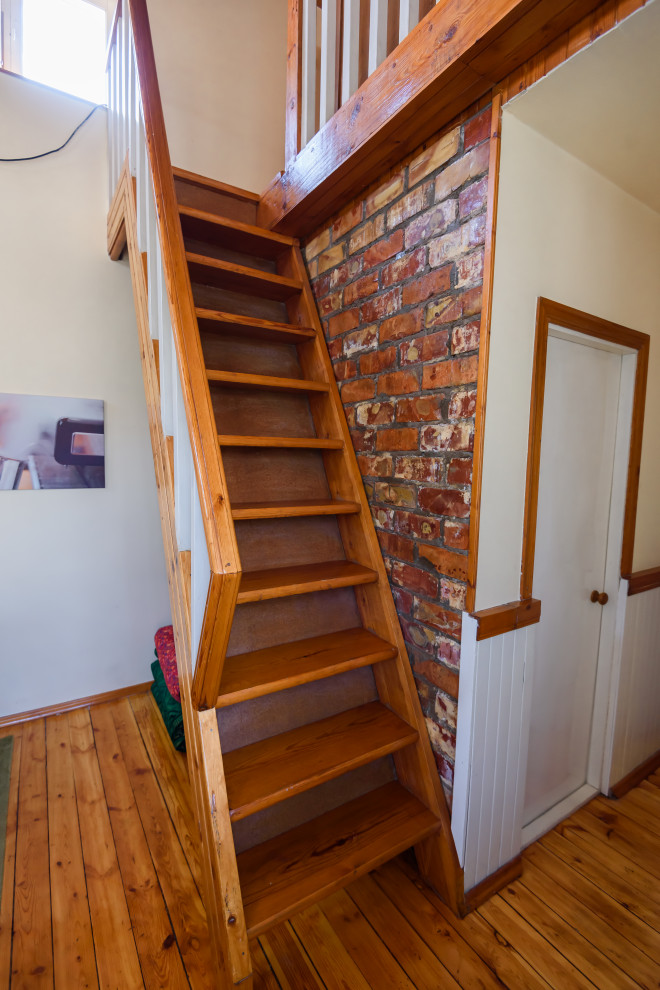 他の地域にあるお手頃価格の小さなインダストリアルスタイルのおしゃれな階段 (レンガ壁) の写真