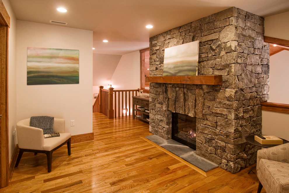 Idées déco pour un salon classique ouvert avec un mur beige, un sol en bois brun, une cheminée standard et un manteau de cheminée en pierre.