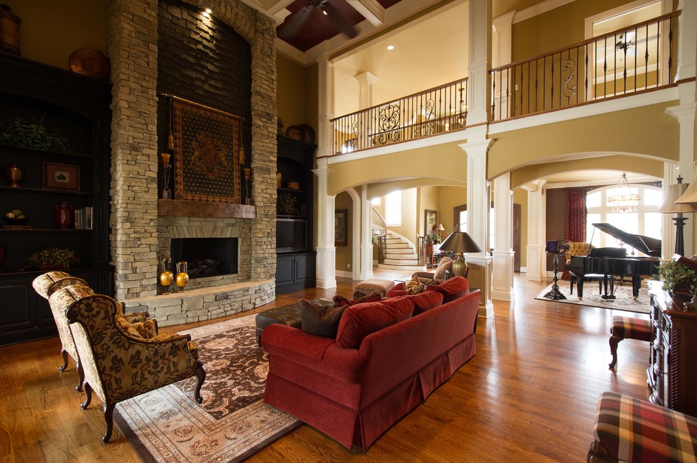 Huge elegant formal and enclosed medium tone wood floor living room photo in Other with beige walls, a standard fireplace and a stone fireplace