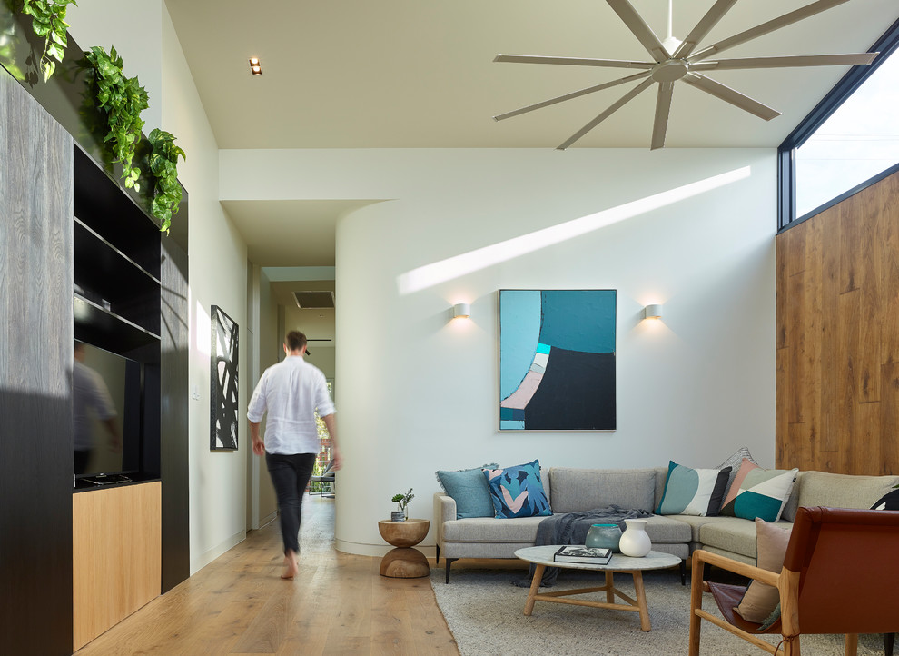 Esempio di un soggiorno design con pareti bianche, TV autoportante e pavimento marrone