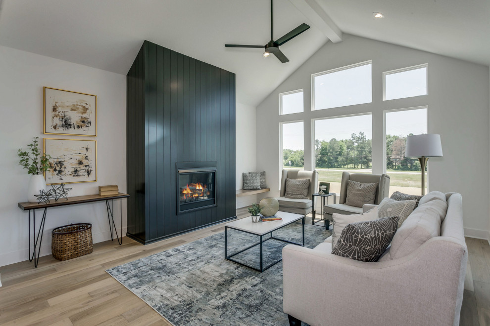Inspiration for a medium sized country open plan living room in Wichita with light hardwood flooring, a standard fireplace, a timber clad chimney breast and a vaulted ceiling.