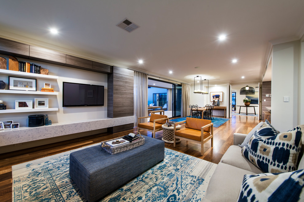 Стильный дизайн: открытая гостиная комната в современном стиле с паркетным полом среднего тона и телевизором на стене - последний тренд