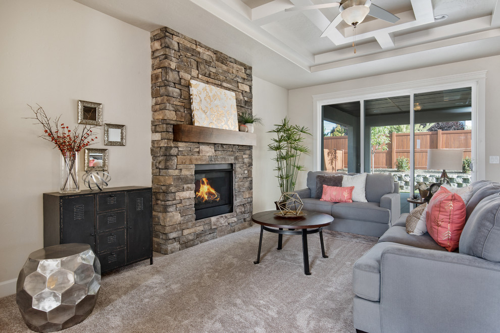 Photo of a medium sized classic open plan living room in Boise with beige walls, carpet, a standard fireplace, a stone fireplace surround and a wall mounted tv.