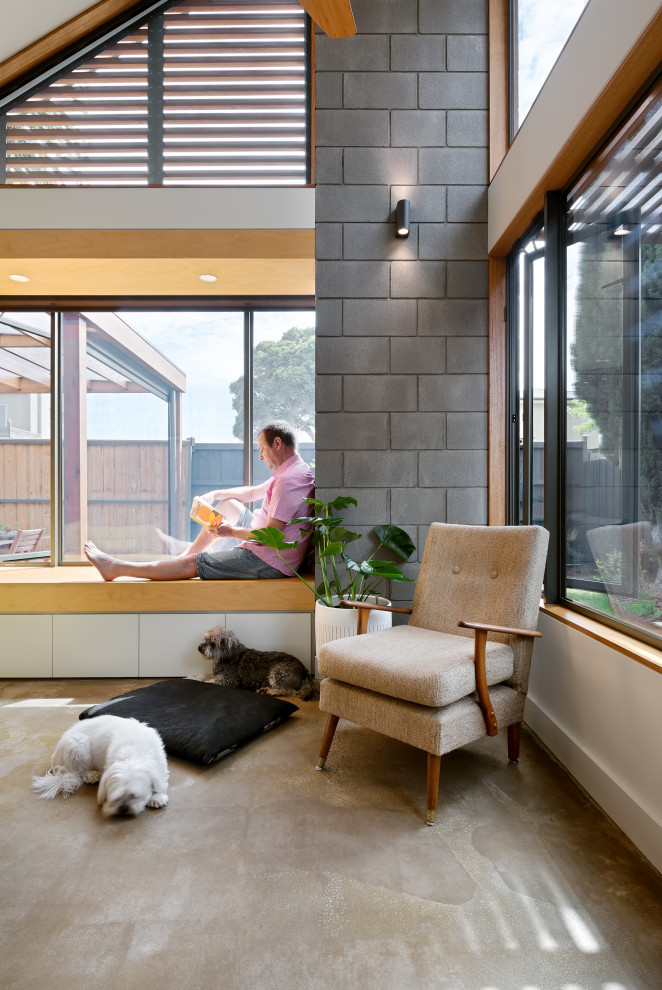 Aménagement d'un petit salon contemporain ouvert avec sol en béton ciré, un plafond voûté et un mur en parement de brique.