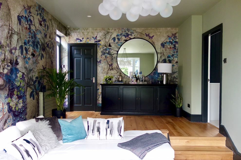 Источник вдохновения для домашнего уюта: гостиная комната среднего размера в стиле фьюжн с домашним баром, зелеными стенами, паркетным полом среднего тона и телевизором на стене
