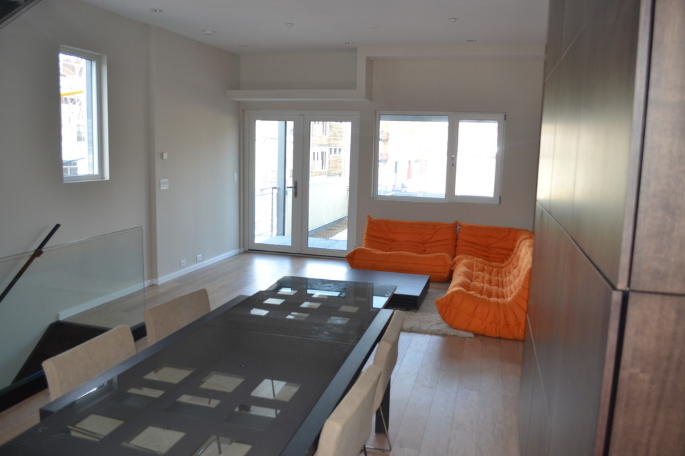 На фото: гостиная комната в стиле модернизм с паркетным полом среднего тона, коричневым полом и бежевыми стенами