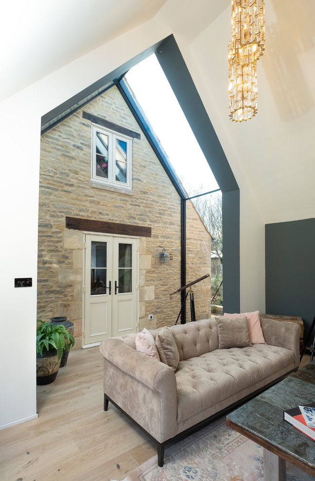 Offenes Modernes Wohnzimmer mit beiger Wandfarbe und hellem Holzboden in Gloucestershire