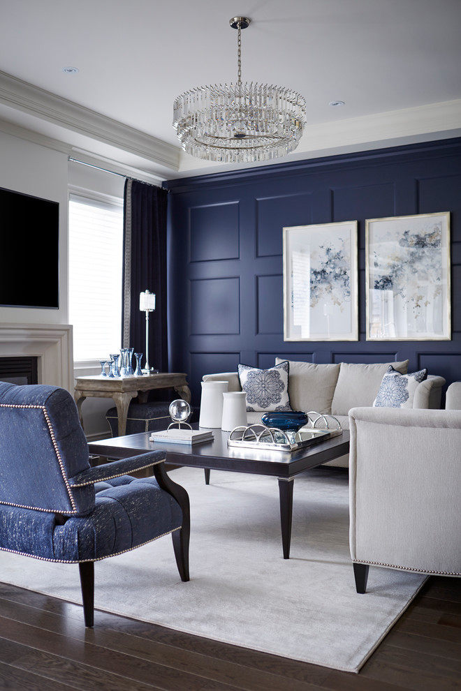 Idée de décoration pour un salon tradition de taille moyenne et fermé avec un mur bleu, un sol en bois brun, une cheminée standard et un téléviseur fixé au mur.