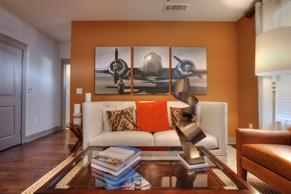 Modelo de salón abierto clásico renovado pequeño con parades naranjas, suelo de madera oscura y televisor colgado en la pared