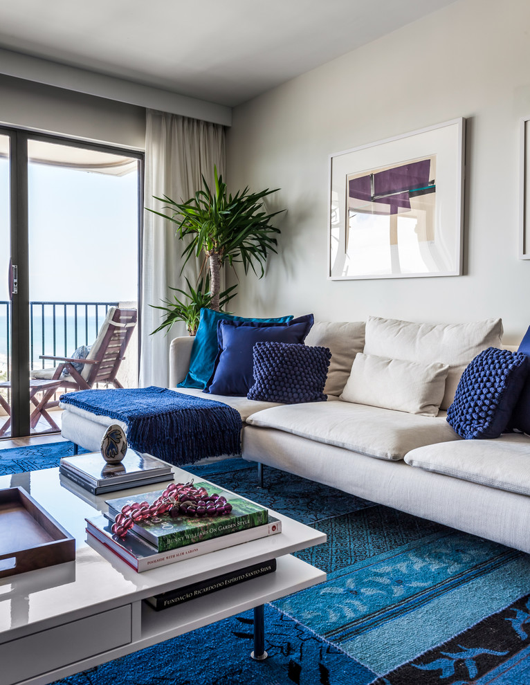 Esempio di un soggiorno stile marino aperto con pareti beige, pavimento in vinile, TV a parete e pavimento beige