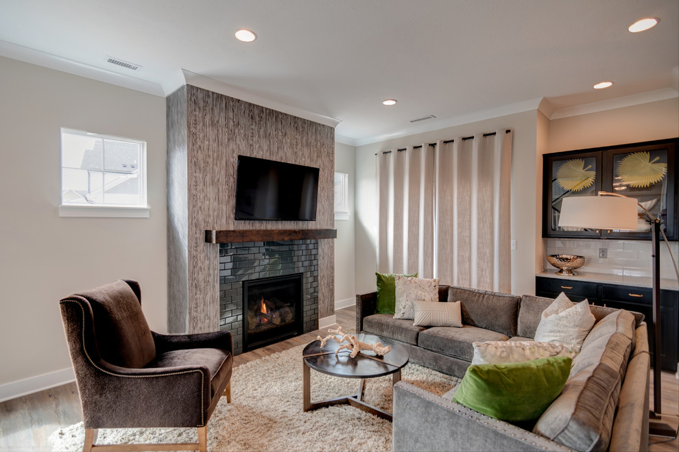 Small minimalist open concept vinyl floor and brown floor living room photo in Indianapolis with beige walls, a standard fireplace, a tile fireplace and a wall-mounted tv