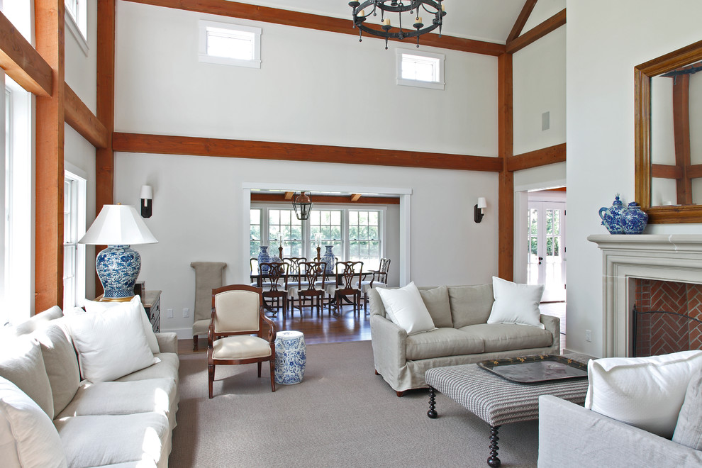 На фото: большая открытая гостиная комната в классическом стиле с белыми стенами, ковровым покрытием, стандартным камином и фасадом камина из камня без телевизора