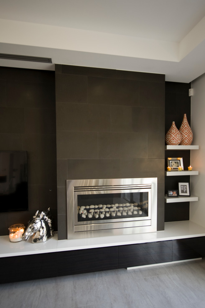 Foto de salón abierto moderno extra grande con paredes negras, suelo de baldosas de porcelana, marco de chimenea de piedra y televisor colgado en la pared