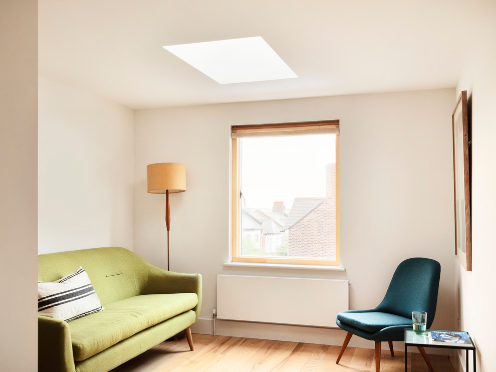 Small scandinavian enclosed living room in London with a reading nook, white walls, light hardwood flooring, no fireplace, no tv and yellow floors.