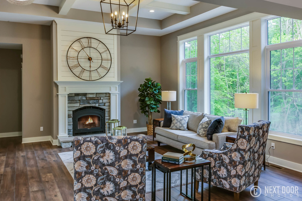 This is an example of a medium sized rural formal open plan living room in Grand Rapids with grey walls, laminate floors, a standard fireplace and a stone fireplace surround.